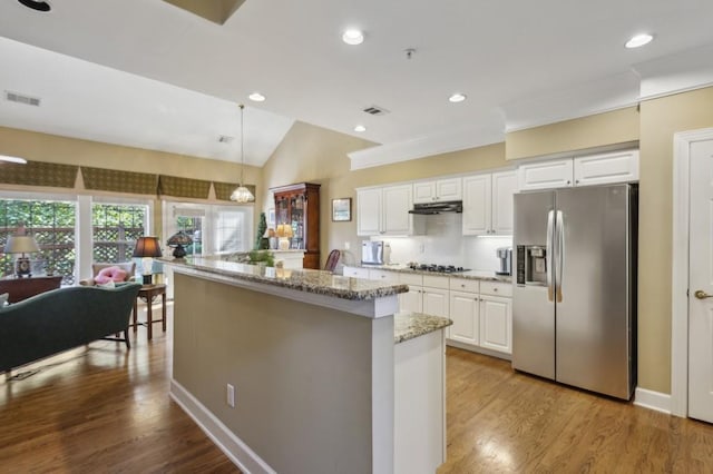 kitchen featuring hanging light fixtures, white cabinetry, vaulted ceiling, light hardwood / wood-style flooring, and stainless steel refrigerator with ice dispenser