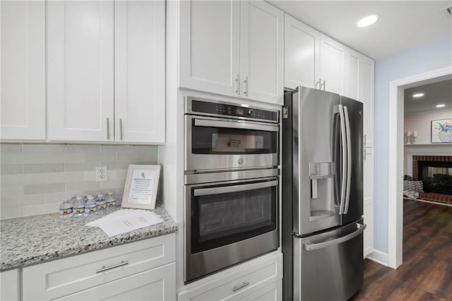 1223 Whitlock Ridge Dr SW, Marietta, GA 30064 - kitchen with stainless steel appliances, tasteful backsplash, white cabinets, light stone counters, and recessed lighting