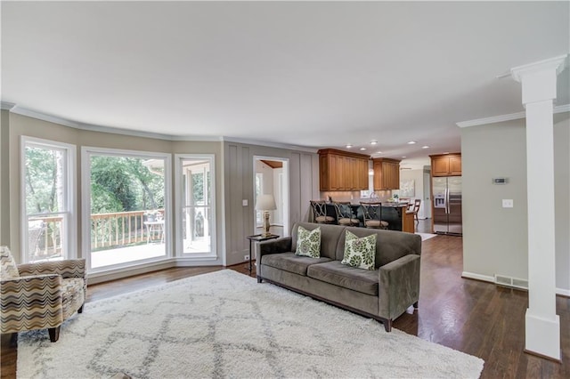 4246 Stilson Cir, Peachtree Corners, GA 30092 - living room featuring crown molding, dark wood-type flooring, recessed lighting, baseboards, and decorative columns