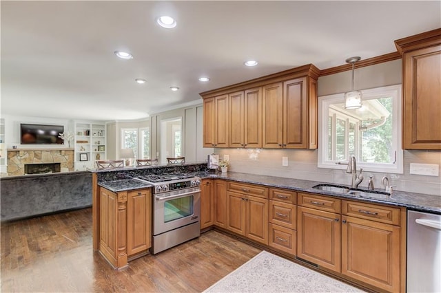 4246 Stilson Cir, Peachtree Corners, GA 30092 - kitchen featuring appliances with stainless steel finishes, a sink, brown cabinetry, dark wood-type flooring, and ornamental molding