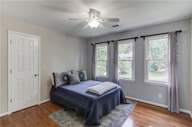 4246 Stilson Cir, Peachtree Corners, GA 30092 - bedroom with wood finished floors, multiple windows, baseboards, and ceiling fan