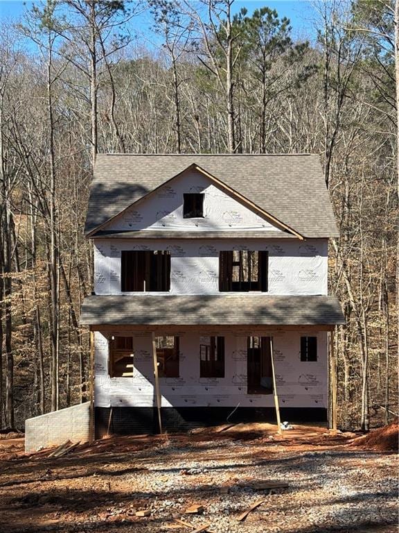 property in mid-construction featuring a wooded view