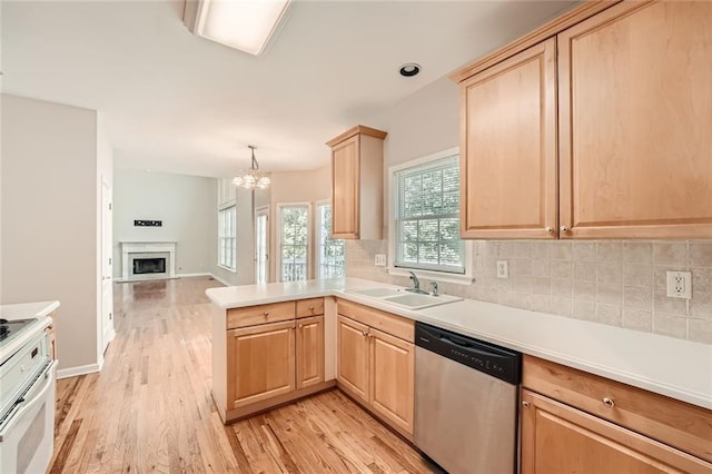 kitchen featuring light brown cabinetry, dishwasher, sink, stove, and kitchen peninsula