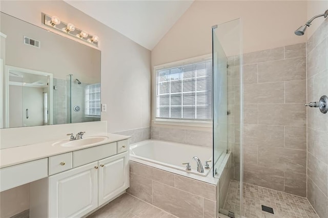 bathroom with vanity, shower with separate bathtub, and vaulted ceiling