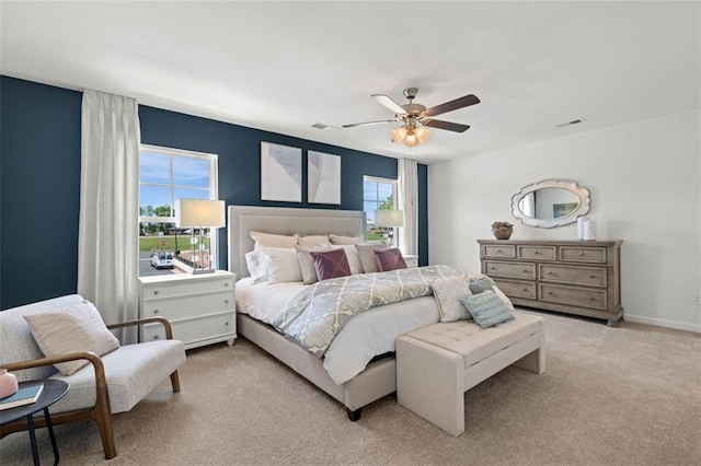 carpeted bedroom with ceiling fan and multiple windows