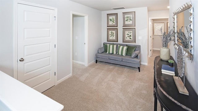 sitting room featuring light colored carpet