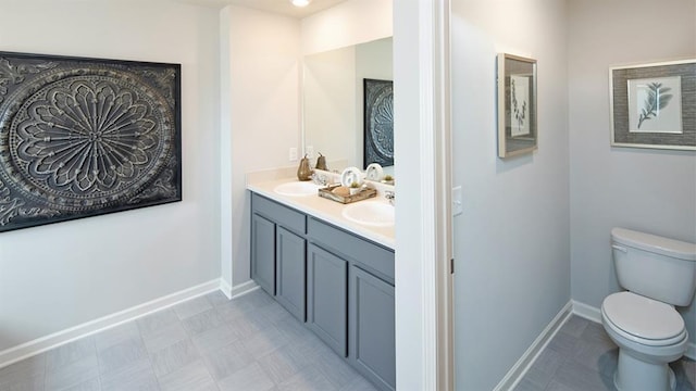 bathroom with double vanity, toilet, and tile patterned flooring