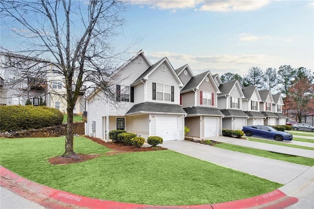 view of front of home featuring a residential view, an attached garage, driveway, and a front yard