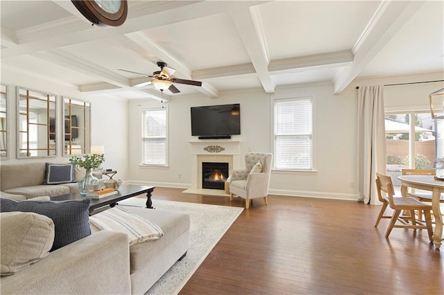 living area featuring a fireplace with flush hearth, beamed ceiling, baseboards, and dark wood-style flooring