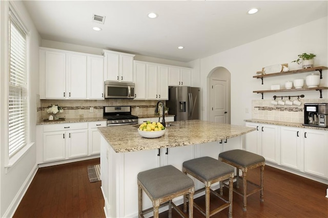 kitchen with plenty of natural light, arched walkways, visible vents, and appliances with stainless steel finishes