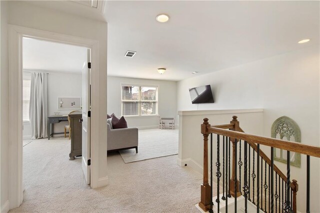 hall featuring visible vents, baseboards, an upstairs landing, light carpet, and recessed lighting