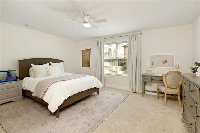 bedroom with visible vents, baseboards, light colored carpet, and ceiling fan