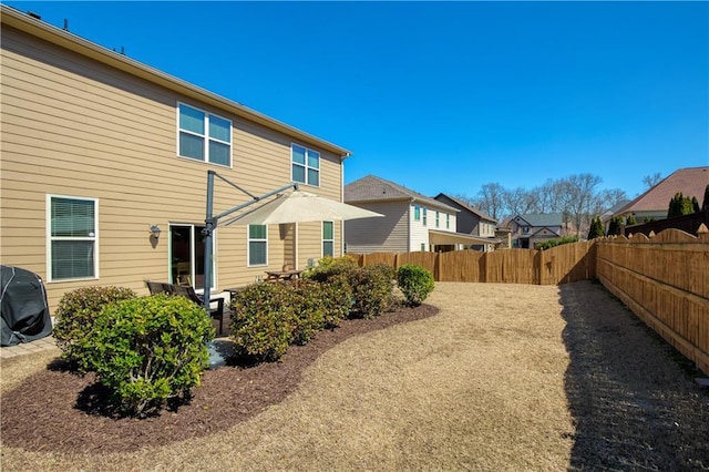 back of property with a residential view, a fenced backyard, and a patio area