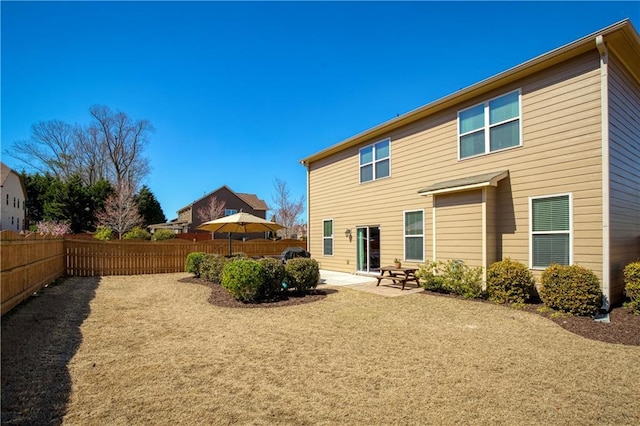 rear view of house with a patio area and fence