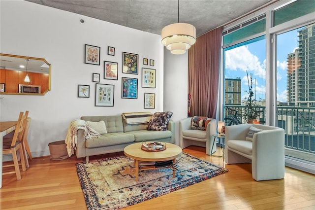 living room with floor to ceiling windows, wood finished floors, and baseboards