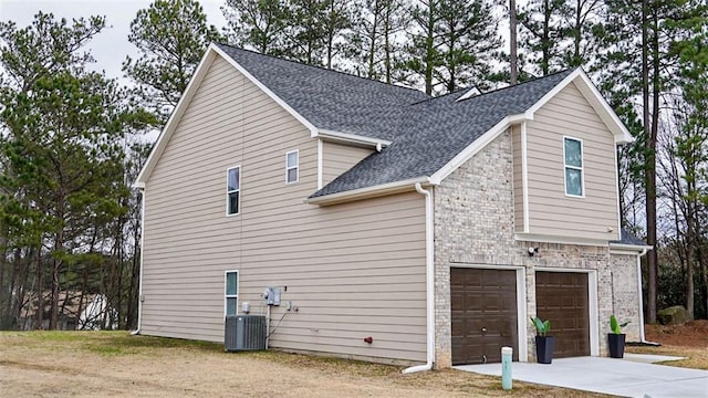 view of side of property featuring a garage and central AC