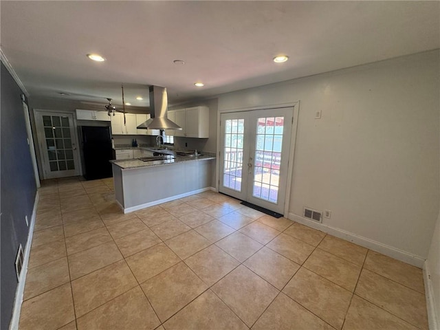 kitchen with white cabinetry, island exhaust hood, kitchen peninsula, black fridge, and french doors