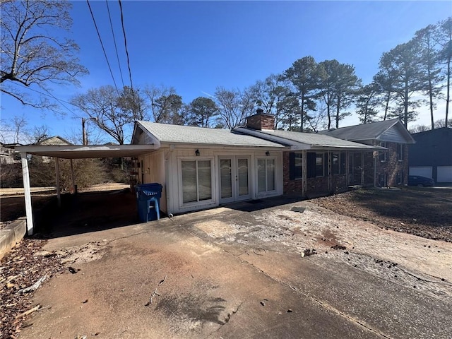 rear view of property featuring a carport and french doors