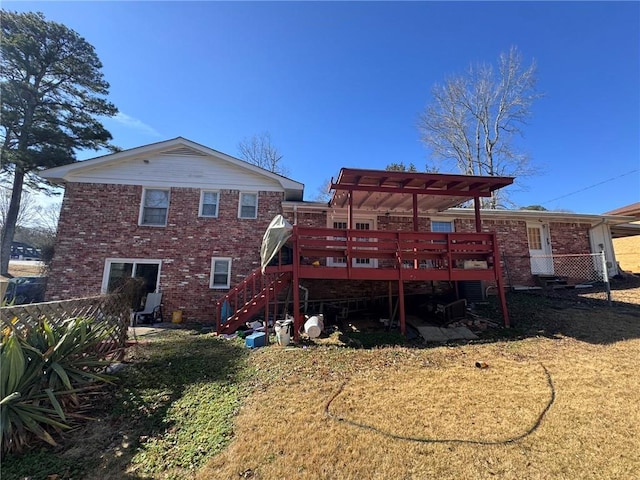 rear view of property featuring a wooden deck and a yard