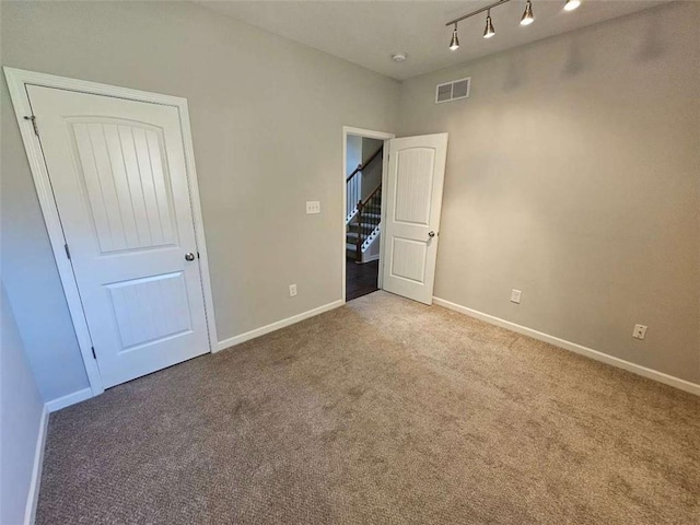1021 Rock Elm Dr, Auburn, GA 30011 - unfurnished bedroom with carpet floors, baseboards, and track lighting