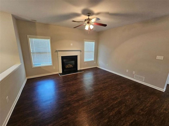 1021 Rock Elm Dr, Auburn, GA 30011 - unfurnished living room featuring dark wood-type flooring, ceiling fan, a fireplace with raised hearth, and baseboards