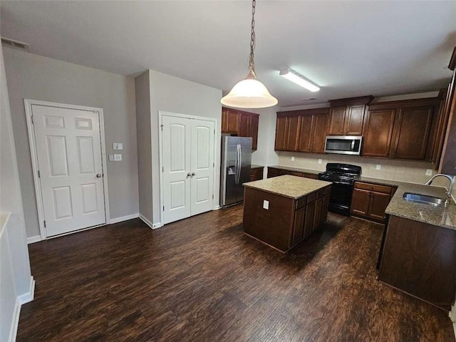 1021 Rock Elm Dr, Auburn, GA 30011 - kitchen featuring stainless steel appliances, a sink, dark wood finished floors, a center island, and hanging light fixtures