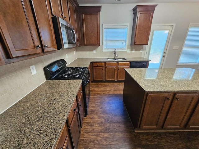 1021 Rock Elm Dr, Auburn, GA 30011 - kitchen featuring black appliances, a sink, dark wood-style floors, stone counters, and tasteful backsplash