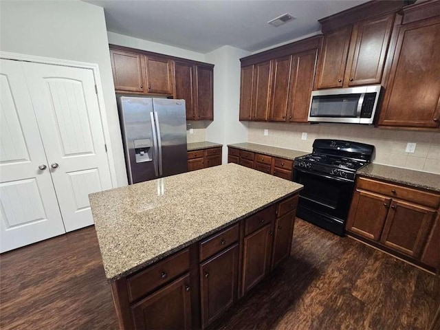 1021 Rock Elm Dr, Auburn, GA 30011 - kitchen featuring stainless steel appliances, dark wood-type flooring, light stone countertops, and a kitchen island