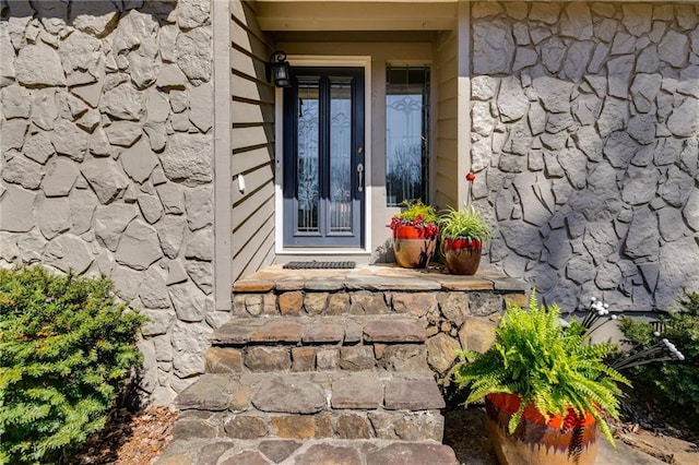 view of exterior entry featuring stone siding