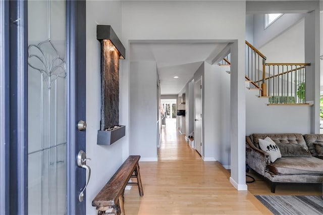 entryway featuring stairway, baseboards, and light wood-type flooring