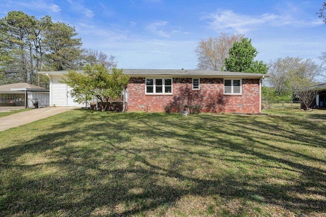 view of front of home with driveway, a front yard, fence, brick siding, and crawl space