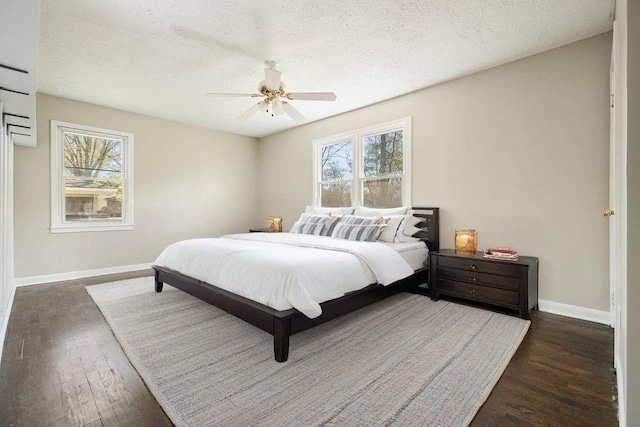 bedroom featuring baseboards, dark wood-style flooring, a textured ceiling, and a ceiling fan