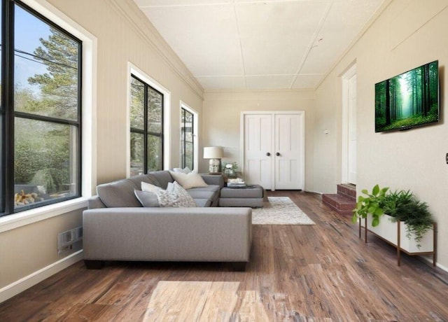 living area with visible vents, baseboards, and wood finished floors