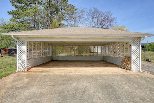 view of parking featuring a carport, fence, and concrete driveway