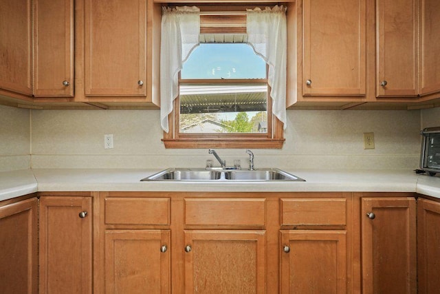 kitchen featuring light countertops and a sink