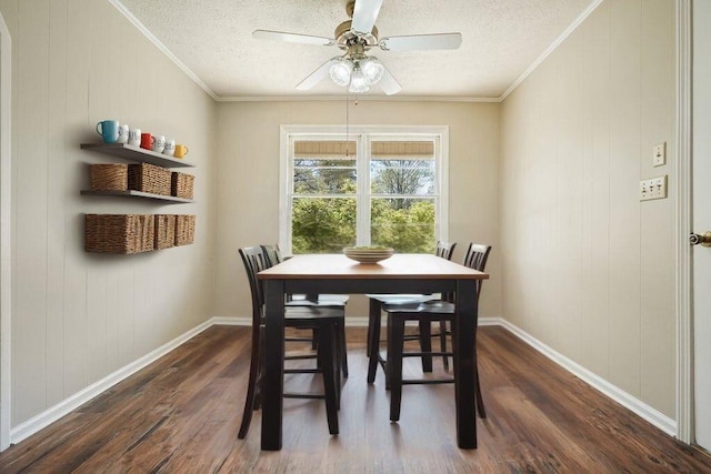 dining space featuring dark wood-style flooring, a textured ceiling, and crown molding
