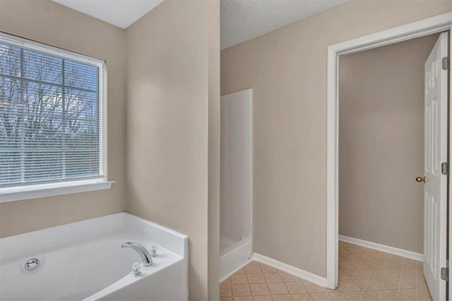 bathroom with a bathtub and a textured ceiling