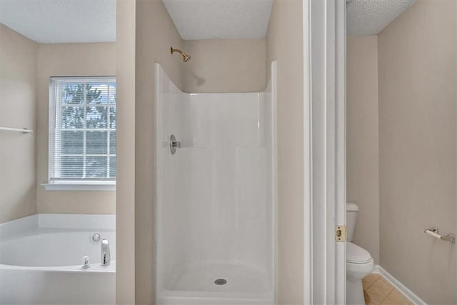 bathroom with a textured ceiling, shower with separate bathtub, and toilet