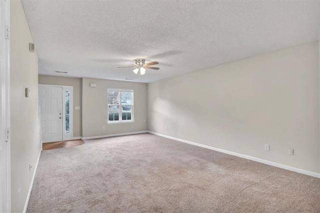 unfurnished room featuring ceiling fan, carpet flooring, and a textured ceiling