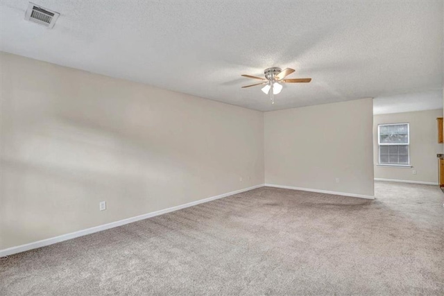 carpeted spare room with a textured ceiling and ceiling fan