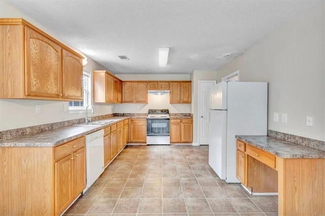 kitchen with sink, built in desk, a textured ceiling, and white appliances