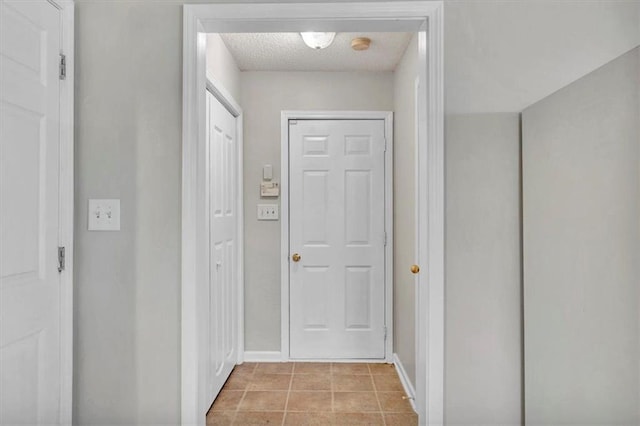 entryway featuring a textured ceiling and light tile patterned floors