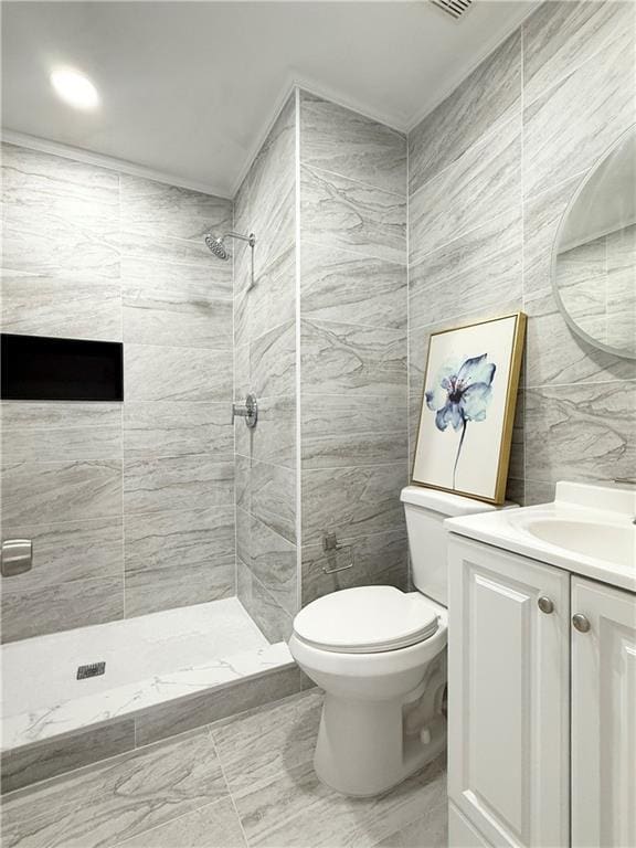 full bath featuring tiled shower, marble finish floor, toilet, and vanity
