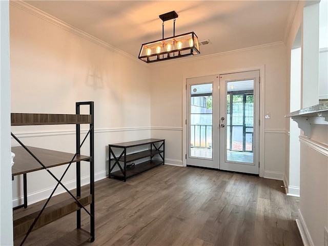 doorway with wood finished floors, crown molding, visible vents, baseboards, and french doors