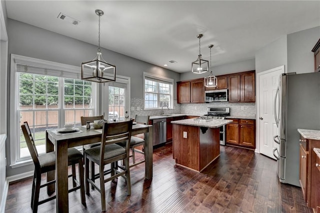 450 Hilingdon Way, Suwanee, GA 30024 - kitchen with stainless steel appliances, a kitchen island, decorative backsplash, a chandelier, and dark wood-style floors