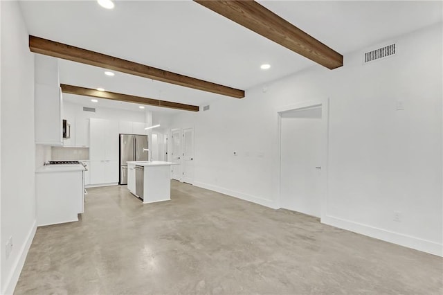 unfurnished living room with beam ceiling