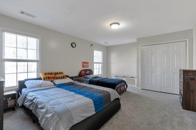 bedroom with a closet and light carpet