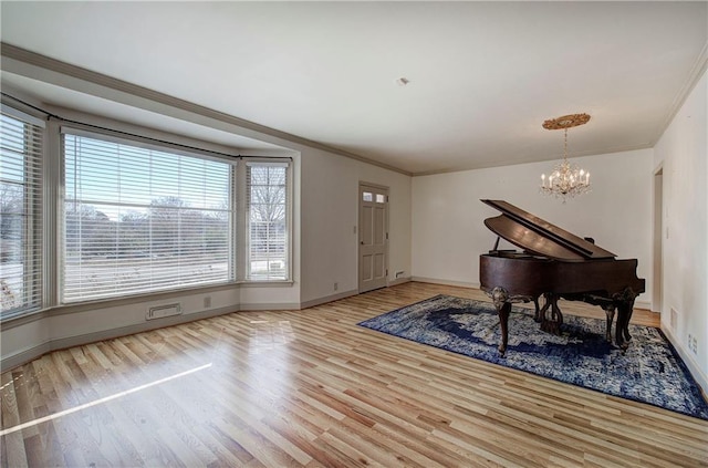 entryway with baseboards, an inviting chandelier, wood finished floors, and crown molding