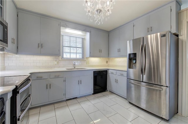 kitchen with a sink, gray cabinetry, light countertops, appliances with stainless steel finishes, and backsplash