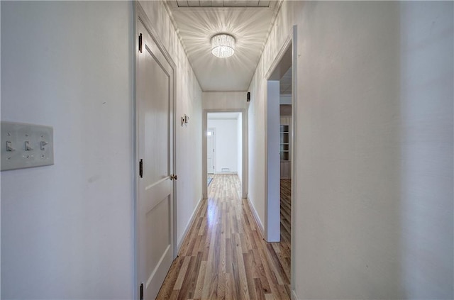 corridor with baseboards and light wood-type flooring